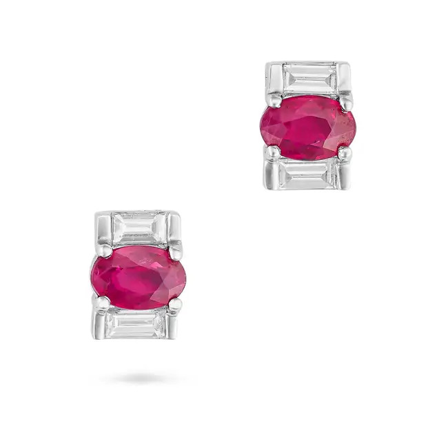 A PAIR OF RUBY AND DIAMOND EARRINGS each set with an oval cut ruby accented by baguette cut