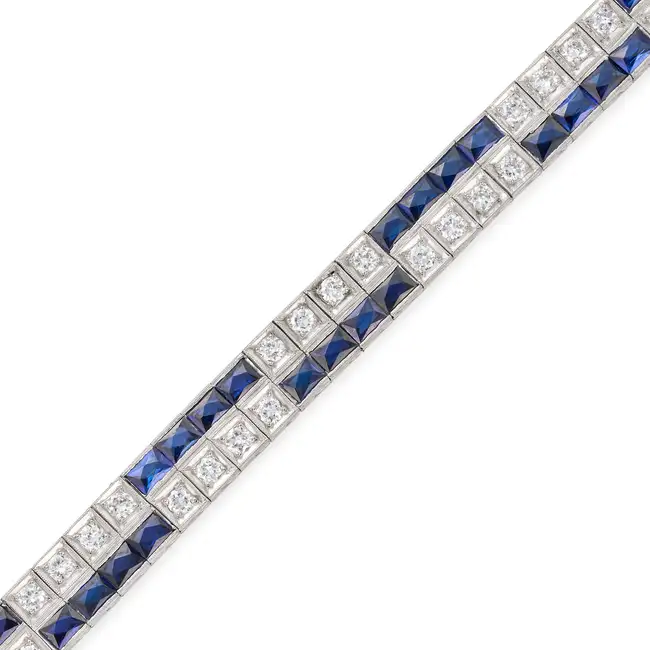 A FINE ART DECO SAPPHIRE AND DIAMOND STRAP BRACELET comprising two rows of French cut sapphires