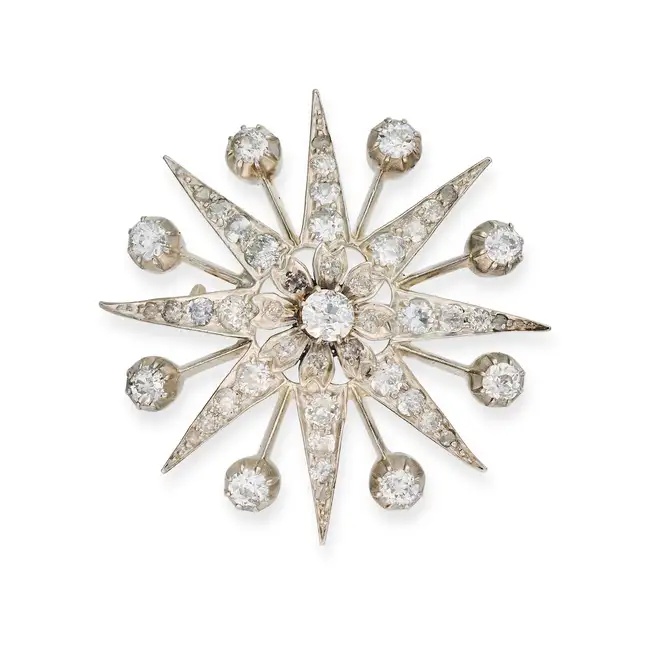 AN ANTIQUE DIAMOND STAR BROOCH designed as an eight rayed star with a foliate centre, set with old