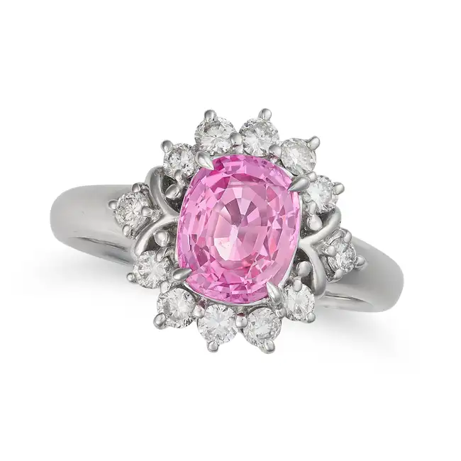 A PINK SAPPHIRE AND DIAMOND CLUSTER RING set with an oval cut pink sapphire of 2.42 carats within