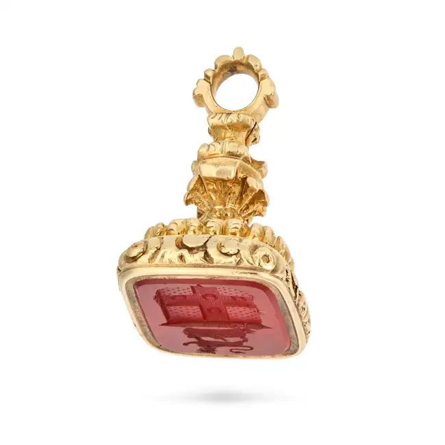 AN ANTIQUE CARNELIAN FOB SEAL / PENDANT the foliate style body set with a carnelian intaglio