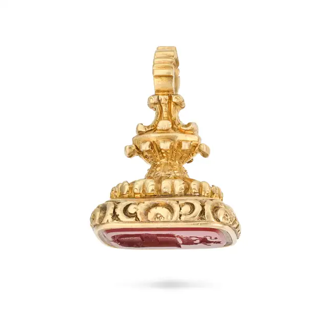 AN ANTIQUE CARNELIAN FOB SEAL / PENDANT the foliate style body set with a carnelian intaglio