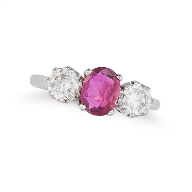 A RUBY AND DIAMOND THREE STONE RING set with an oval cut ruby of approximately 0.91 carats between