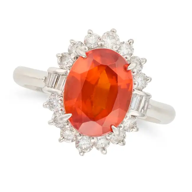 A SPESSARTINE GARNET AND DIAMOND CLUSTER RING set with an oval cut spessartine garnet of 3.98 carats