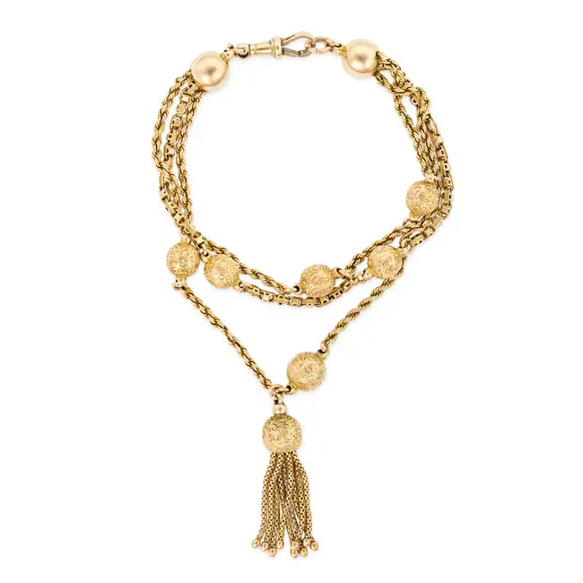 AN ANTIQUE TASSEL BRACELET comprising three rows of twisted and fancy links, punctuated by by