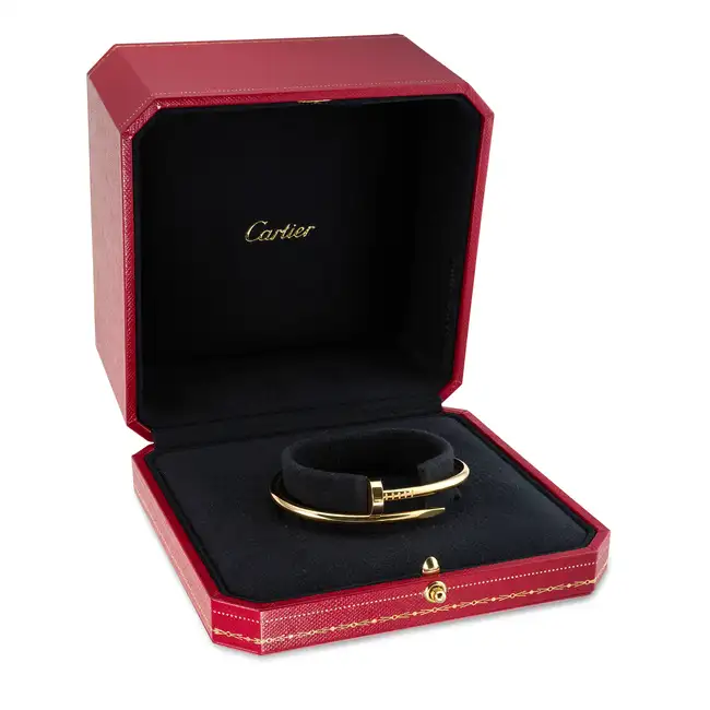 CARTIER, A CLASSIC MODEL JUSTE UN CLOU BANGLE in 18ct yellow gold, designed as bent nail, signed