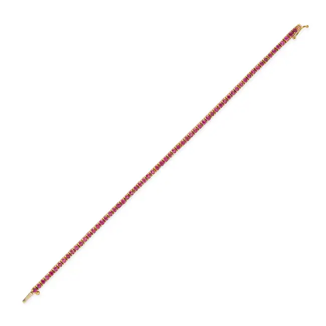 A RUBY LINE BRACELET in 18ct yellow gold, comprising a row of round cut rubies, stamped 750, 16.5cm,