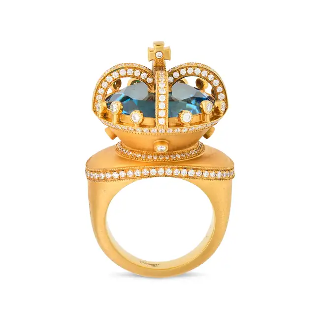 CARATIFF, A BLUE TOPAZ AND DIAMOND CROWN DRESS RING designed as a crown set with a blue topaz of