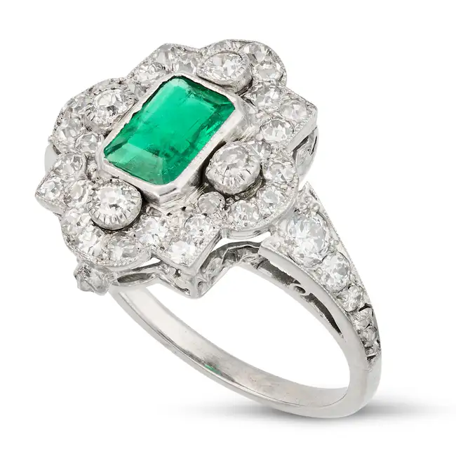 AN EMERALD AND DIAMOND DRESS RING, EARLY 20TH CENTURY set with an octagonal step cut emerald of