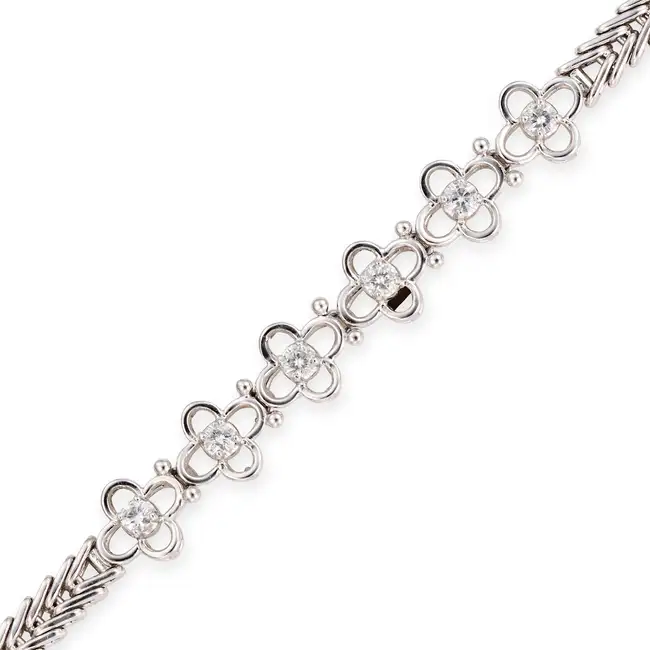 A DIAMOND BRACELET designed as a row of flowers set with round brilliant cut diamonds totalling 0.42