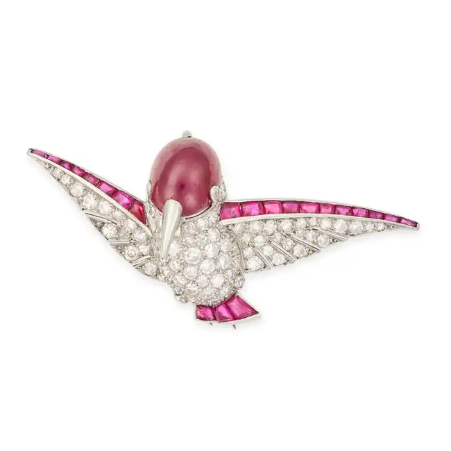 A RUBY AND DIAMOND HUMMINGBIRD BROOCH designed as a hummingbird in flight, the head set with a
