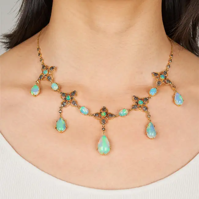 AN OPAL AND DIAMOND NECKLACE in silver gilt, comprising a row of openwork quatrefoil motifs set with