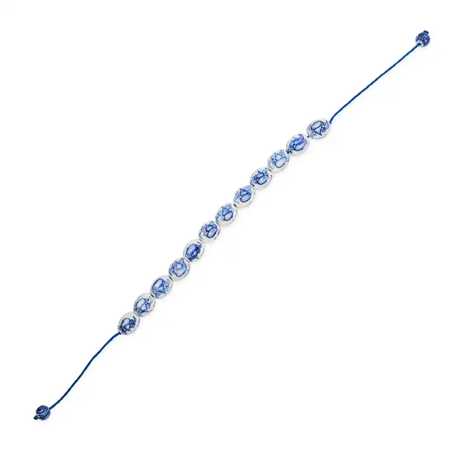 NO RESERVE - A PORCELAIN BEAD BRACELET comprising a row of painted blue and white porcelain beads,