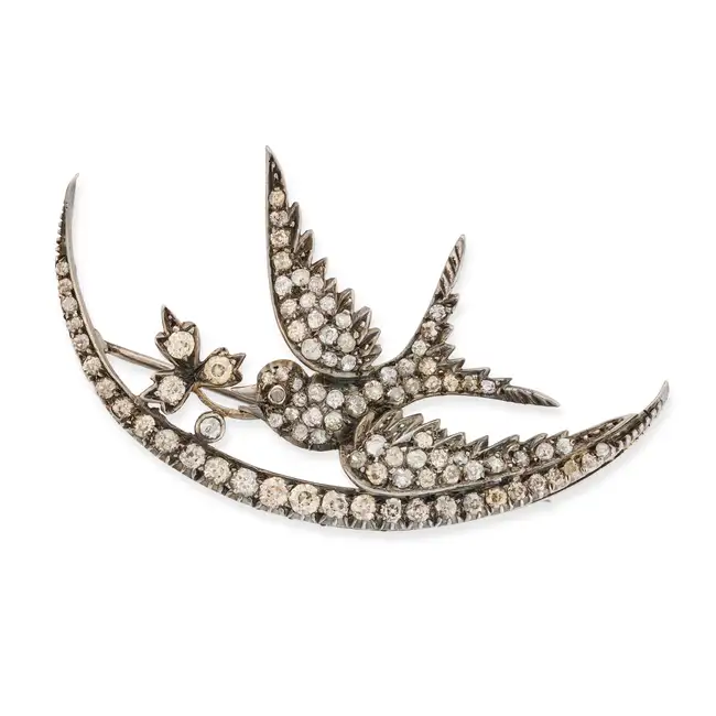 AN ANTIQUE DIAMOND CRESCENT MOON AND SWALLOW BROOCH in yellow gold and silver, designed as a
