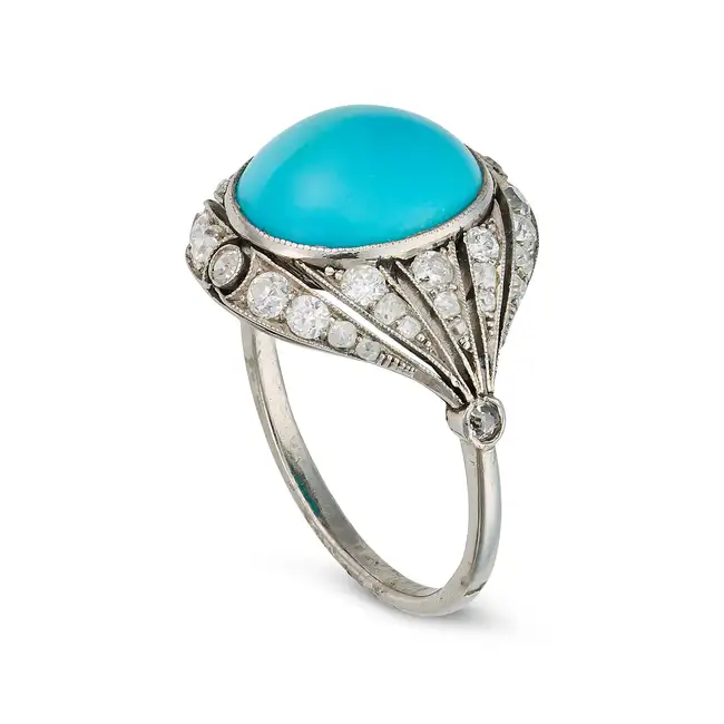 AN ANTIQUE TURQUOISE AND DIAMOND DRESS RING, CIRCA 1920 in platinum, set with an oval cabochon