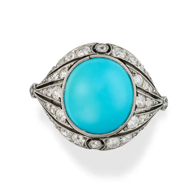 AN ANTIQUE TURQUOISE AND DIAMOND DRESS RING, CIRCA 1920 in platinum, set with an oval cabochon