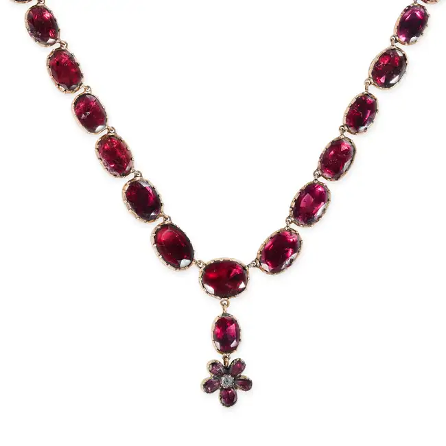 AN ANTIQUE GARNET RIVIERE NECKLACE the necklace comprising a row of oval and cushion cut garnets,