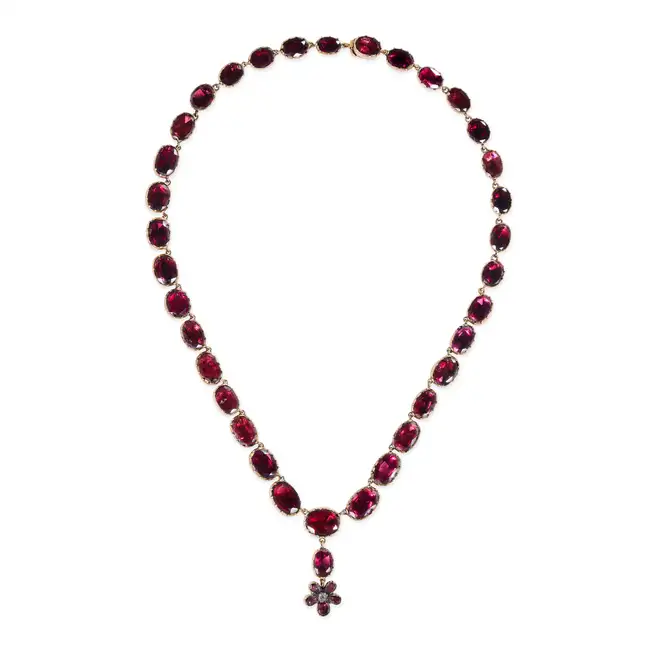 AN ANTIQUE GARNET RIVIERE NECKLACE the necklace comprising a row of oval and cushion cut garnets,