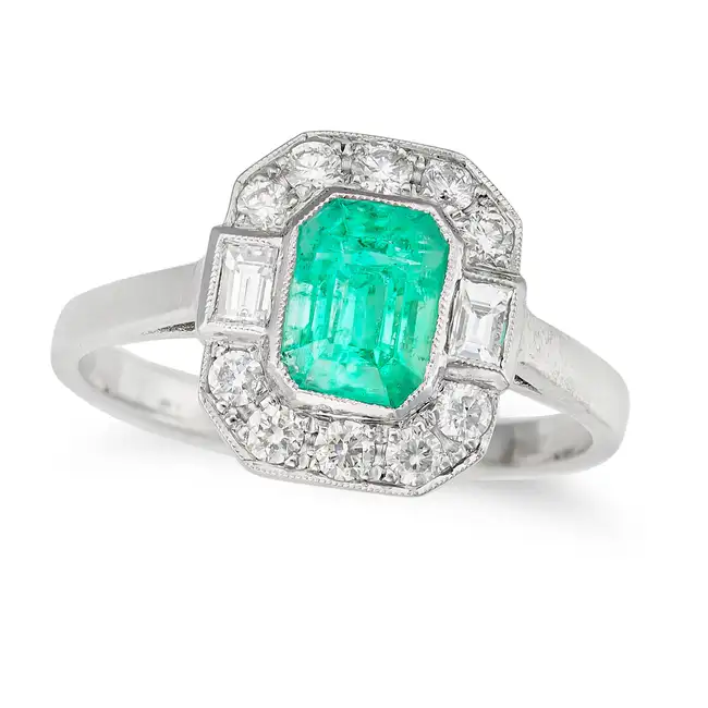 AN EMERALD AND DIAMOND DRESS RING in platinum, set with an octagonal step cut emerald of