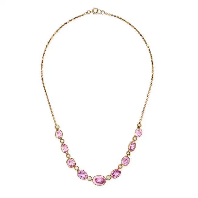 AN ANTIQUE PINK TOPAZ AND PEARL NECKLACE  comprising a row of alternating oval cut pink topaz and