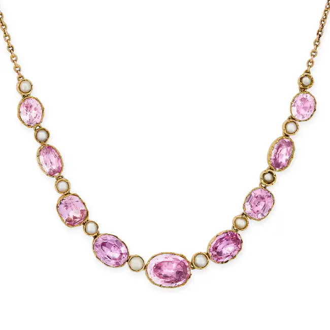 AN ANTIQUE PINK TOPAZ AND PEARL NECKLACE  comprising a row of alternating oval cut pink topaz and