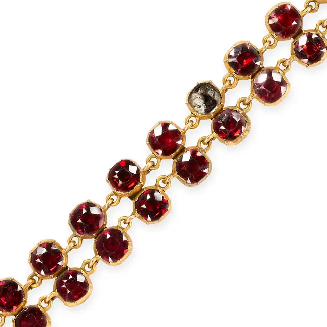 NO RESERVE - AN ANTIQUE GARNET BRACELET comprising two rows of cushion cut garnets, two garnets