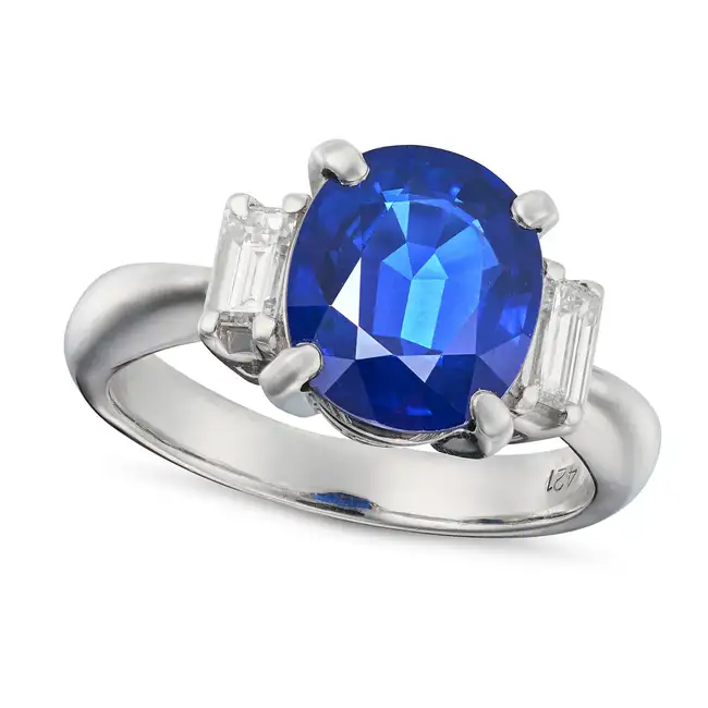 A SAPPHIRE AND DIAMOND THREE STONE RING set with an oval cut sapphire of 4.21 carat between two