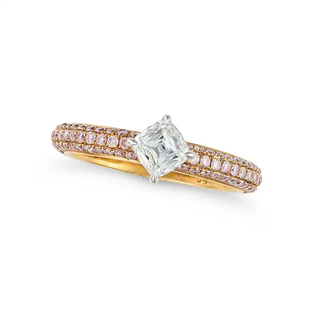 A DIAMOND AND PINK DIAMOND DRESS RING in 18ct yellow gold, set with a fancy cut diamond of 0.54