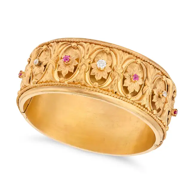 AN ANTIQUE VICTORIAN RUBY AND DIAMOND BANGLE in yellow gold, the hinged bangle decorated with a