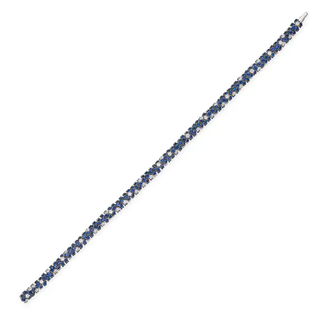 A SAPPHIRE AND DIAMOND BRACELET set throughout with round cut sapphires, accented by round brilliant