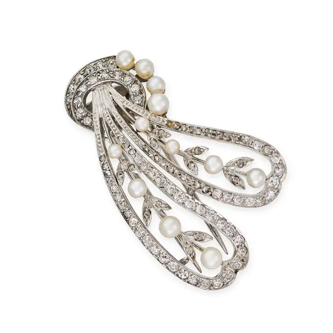 AN ANTIQUE DIAMOND AND PEARL CLIP BROOCH, EARLY 20TH CENTURY the stylised scrolling brooch set