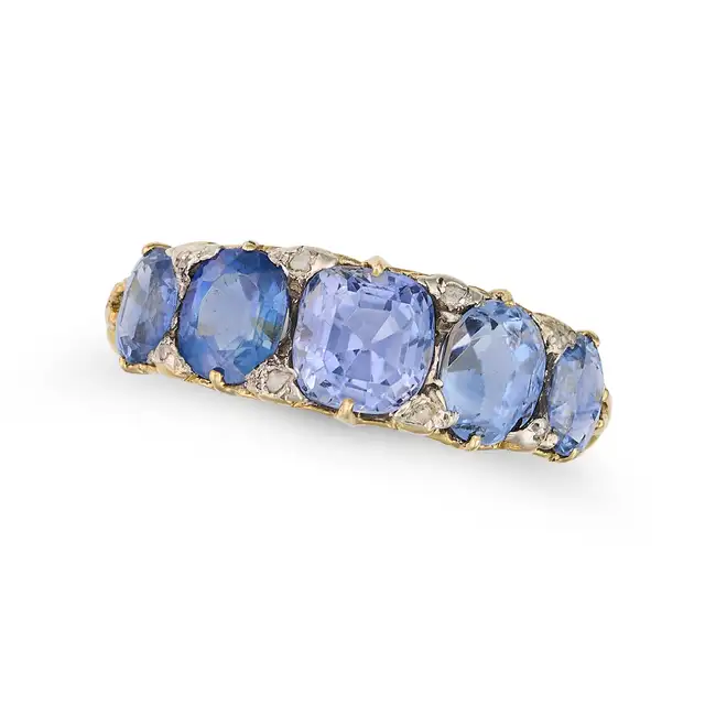 AN ANTIQUE SAPPHIRE FIVE STONE RING in yellow gold, set with five cushion and oval cut sapphires,