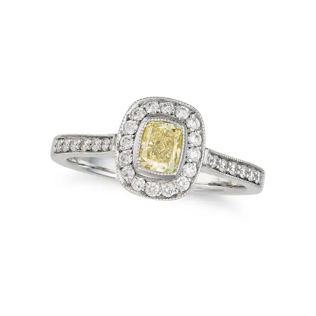 A FANCY YELLOW DIAMOND RING in platinum, set with a radiant cut diamond of 0.50 carats in a border