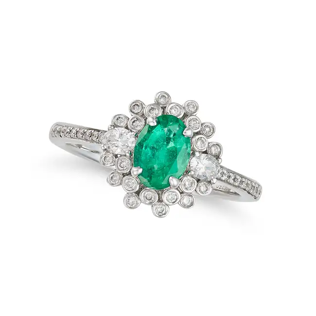 AN EMERALD AND DIAMOND DRESS RING in 18ct white gold, set with an oval cut emerald of