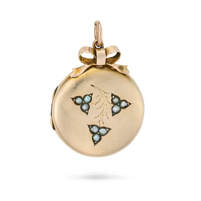 AN ANTIQUE VICTORIAN PEARL LOCKET PENDANT the circular hinged locket with foliate motifs set with