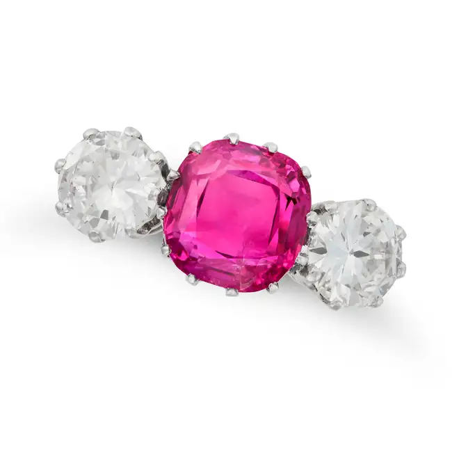 A FINE BURMA NO HEAT RUBY AND DIAMOND THREE STONE RING in 18ct white gold, set with a cushion cut