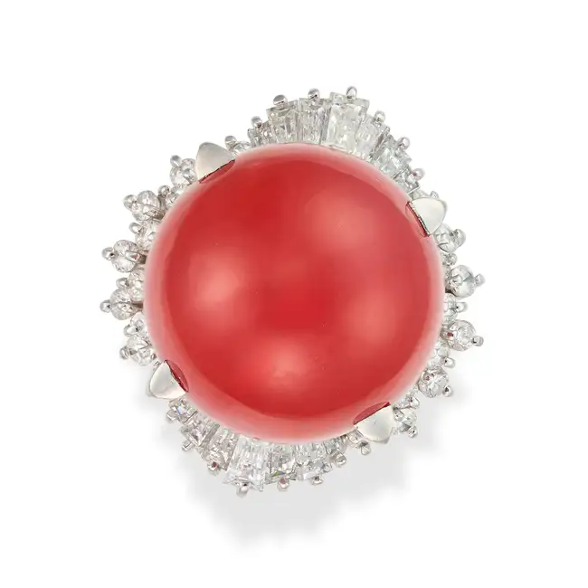 A FINE RED CORAL AND DIAMOND RING set with a large red coral bead of 16.2mm, the border set with