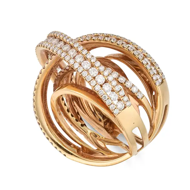 A DIAMOND DRESS RING the stylised ring in cross over design, accented by round brilliant cut