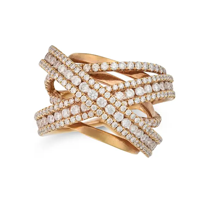 A DIAMOND DRESS RING the stylised ring in cross over design, accented by round brilliant cut