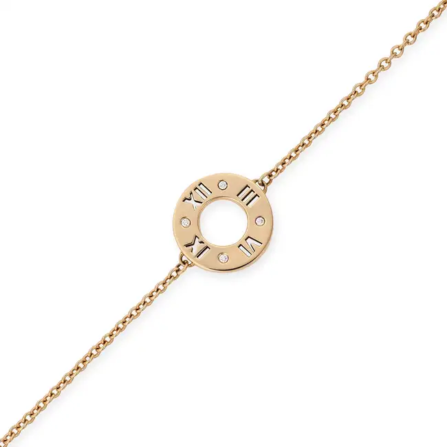 TIFFANY & CO., A DIAMOND ATLAS BRACELET comprising a circular disc with cut out Roman numerals,