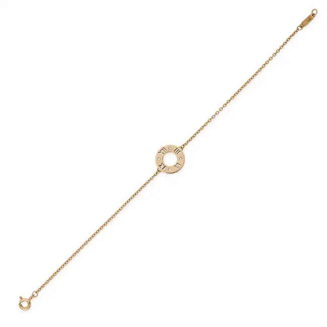 TIFFANY & CO., A DIAMOND ATLAS BRACELET comprising a circular disc with cut out Roman numerals,