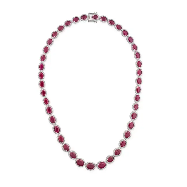 OSCAR FRIEDMAN, A RUBY AND DIAMOND NECKLACE set with a graduating row of oval cut rubies in