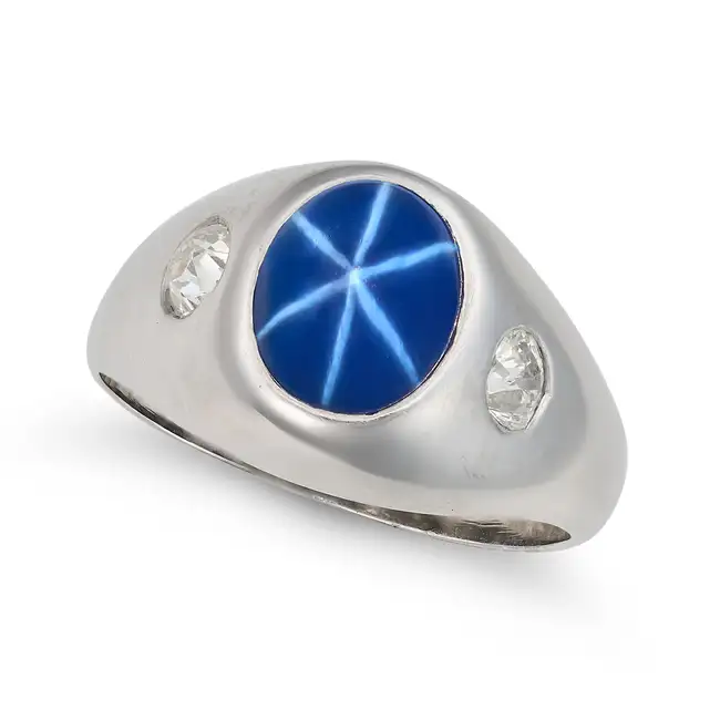 A SYNTHETIC STAR SAPPHIRE AND DIAMOND RING set with a cabochon star sapphire of approximately 3.10