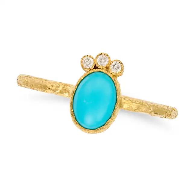 A TURQUOISE AND DIAMOND RING set with an oval cabochon turquoise accented by a trio of round