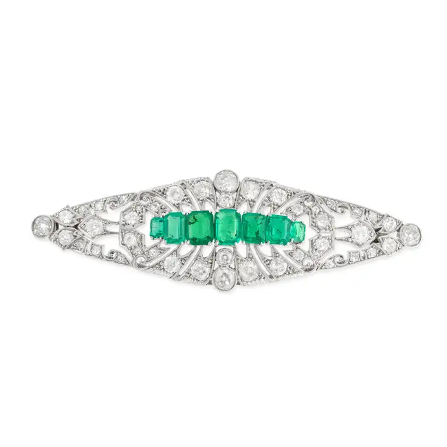 AN ANTIQUE EMERALD AND DIAMOND BROOCH the tapering openwork brooch set with seven octagonal step cut