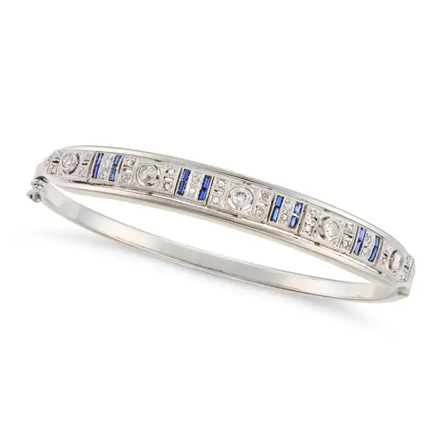 A RETRO DIAMOND AND SAPPHIRE BANGLE in 14ct white gold, the hinged bangle set with round and rose
