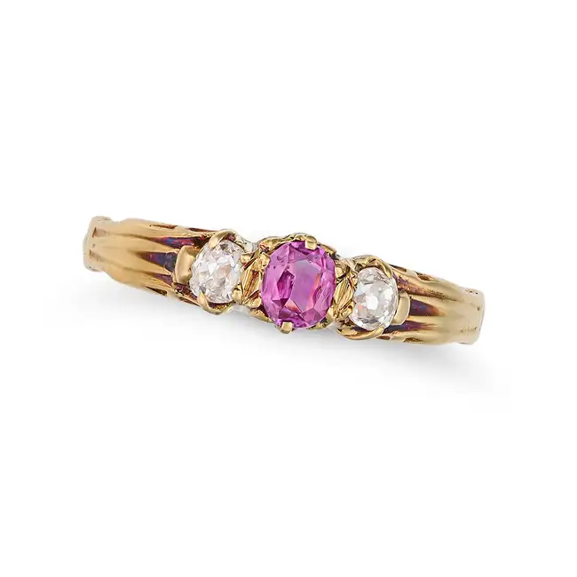 AN ANTIQUE RUBY AND DIAMOND THREE STONE RING in yellow gold, set with an oval cut ruby between two