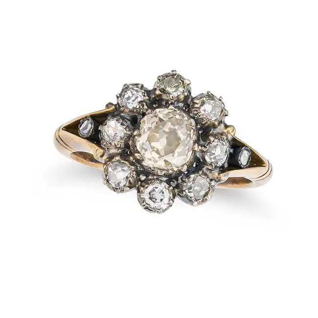 AN ANTIQUE DIAMOND CLUSTER RING in yellow gold and silver, set with an old cut diamond in a