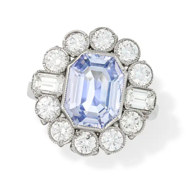 A SAPPHIRE AND DIAMOND CLUSTER RING set with an octagonal step cut sapphire of approximately 4.79