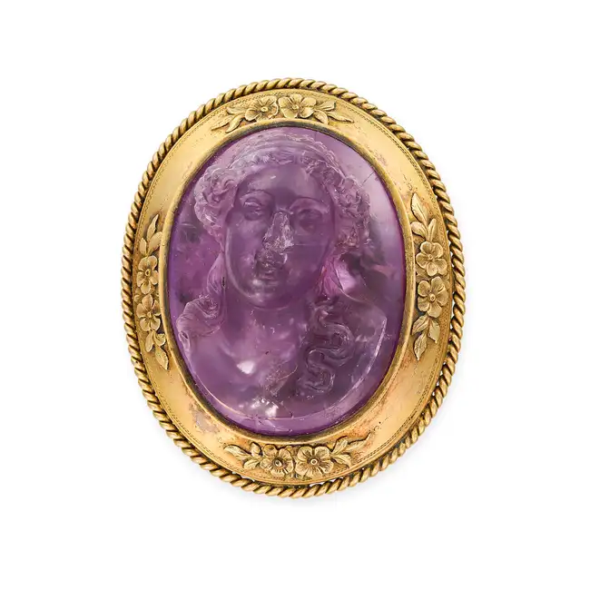 AN ANTIQUE AMETHYST CAMEO BROOCH set with an amethyst cameo carved in high relief, depicting the